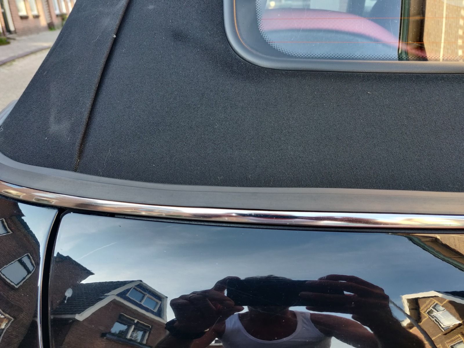 Přechod opraveného těsnění u rohu střechy černého Mini Cabrio